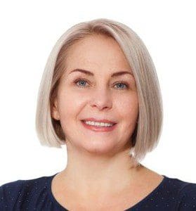 Smiling middle-aged woman with short blonde hair and a navy top.